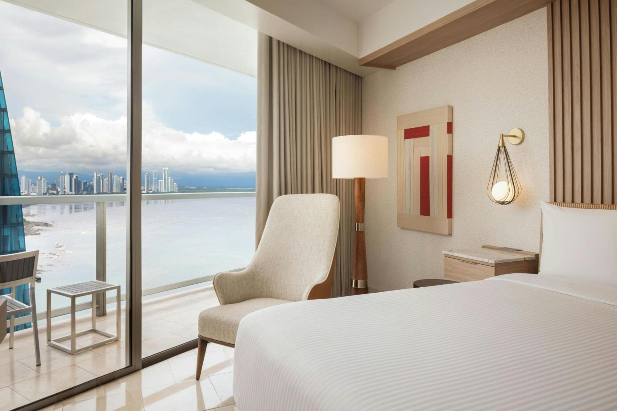 Habitación con cama extragrande, balcón y vistas parciales al océano